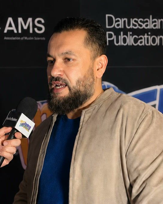 Atif Tanvir, founder of Cre8Aura, speaking into a microphone at an event
